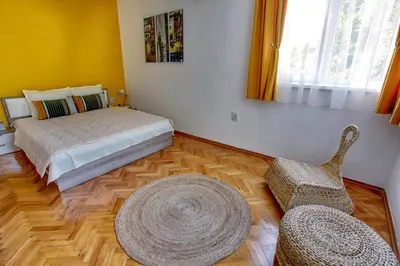 a bedroom with a bed and two chairs and a rug at TERRACE HOME - Three bedrooms City center in Plovdiv