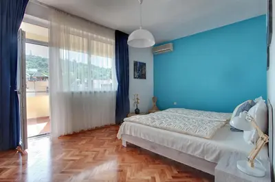 a blue bedroom with a bed and a large window at TERRACE HOME - Three bedrooms City center in Plovdiv
