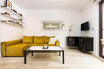 a living room with a yellow couch and a coffee table at Luxury Central Apartment in Plovdiv