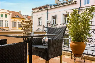 a patio with a table and chairs on a balcony at Luxury Central Apartment in Plovdiv