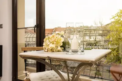 a table with glasses and flowers on a balcony at Luxury Central Apartment in Plovdiv