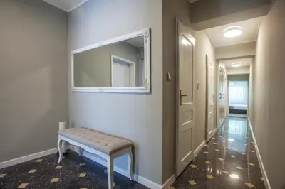 a hallway with a bench and a mirror at Spacious flat close to the American Embassy, free parking place in Sofia