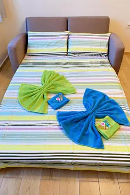 a bed with towels on top of it at Apartment Iris in Plovdiv