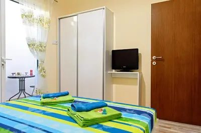 a bedroom with two towels on a bed with a television at Apartment Iris in Plovdiv