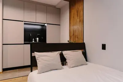a bedroom with a white bed with two pillows at Vinyl Studio Apartment Sofia in Sofia