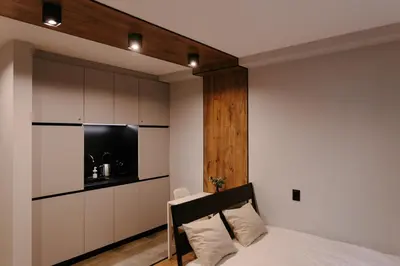 a bedroom with a bed and a wall with cabinets at Vinyl Studio Apartment Sofia in Sofia