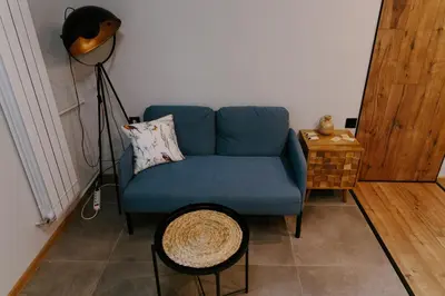 a blue couch in a living room with a table at Vinyl Studio Apartment Sofia in Sofia