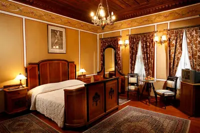 a bedroom with a bed and a chandelier at Old Legends Hotel in Plovdiv