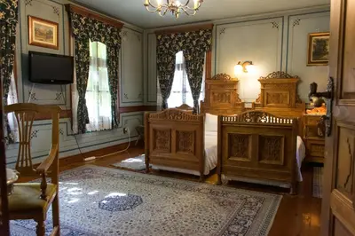 a bedroom with two beds and a tv and two chairs at Old Legends Hotel in Plovdiv