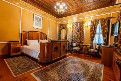 a bedroom with a bed and a chandelier at Old Legends Hotel in Plovdiv