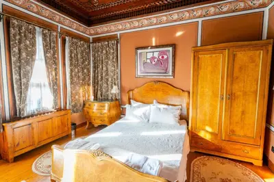 a bedroom with a large bed with a wooden headboard at Old Legends Hotel in Plovdiv