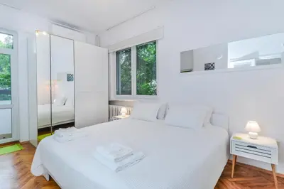 a white bedroom with a large white bed and windows at The Charming Home - One Bedroom TOP Central Apartment by Flat Mаnager in Sofia