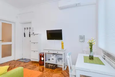a white living room with a table and a tv at The Charming Home - One Bedroom TOP Central Apartment by Flat Mаnager in Sofia