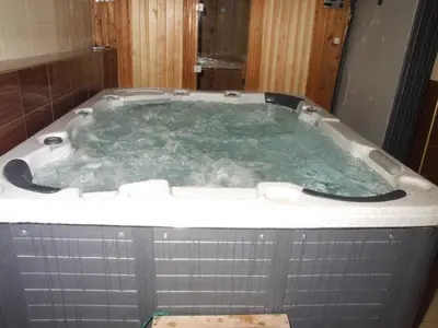 a jacuzzi tub in a bathroom with green water at Family Hotel Dalia in Velingrad