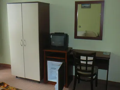 a room with a desk with a tv and a mirror at Къща за гости Типик in Bansko