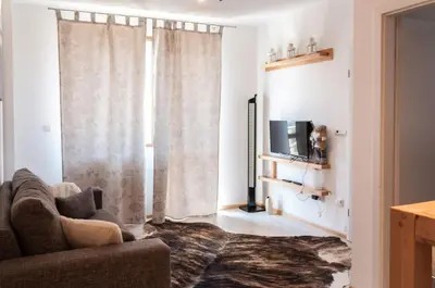 a living room with a couch and a television at Snow Pearl Residence & FREE SPA in Bansko