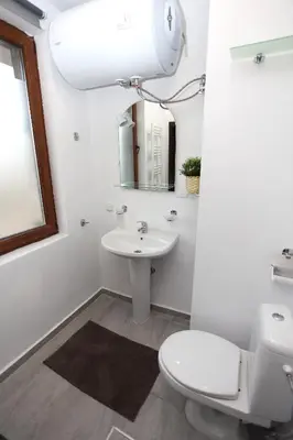 a bathroom with a sink and a toilet and a mirror at Snow Pearl Residence & FREE SPA in Bansko