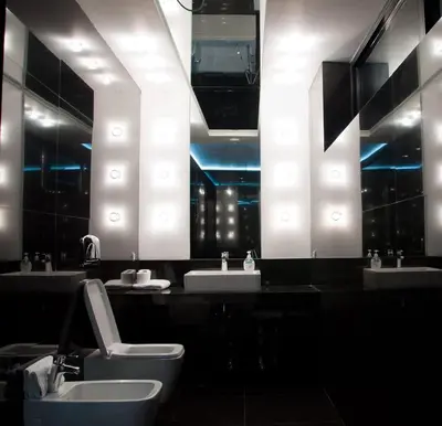 a bathroom with two sinks and a toilet and mirrors at Hotel Fashion - Free Parking in Sofia