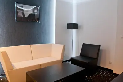 a living room with a white couch and a chair at Hotel Fashion - Free Parking in Sofia