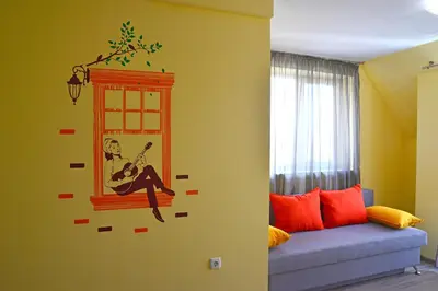 a room with a window with a woman playing a guitar at Visito Aparthouse in Sofia