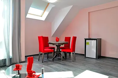 a dining room with red chairs and a table at Visito Aparthouse in Sofia