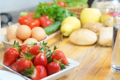a table with strawberries and eggs and other fruits and vegetables at Hostel Mostel Hub Rooms and Apartments in Sofia