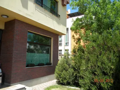a brick building with a window next to a bush at Hotel Diavolo in Sofia