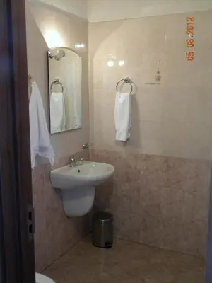 a bathroom with a sink and a mirror and towels at Hotel Diavolo in Sofia