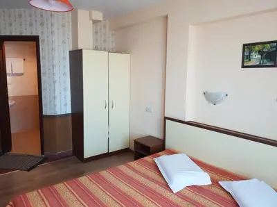 a bedroom with a bed and a white cabinet at Hotel Diavolo in Sofia