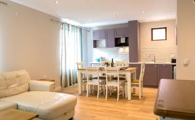 a kitchen and living room with a table and chairs at Predela 2 Aparthotel in Bansko