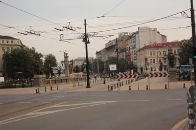 an empty street in a city with buildings and power lines at Botev Apartment in Sofia