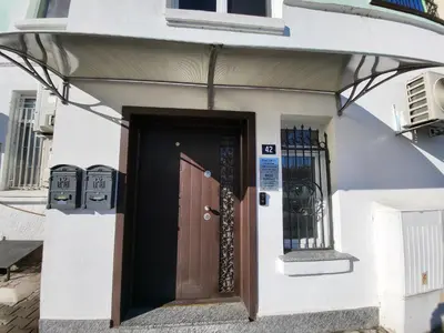a front door of a white building with a brown door at Hotel Odeon in Plovdiv