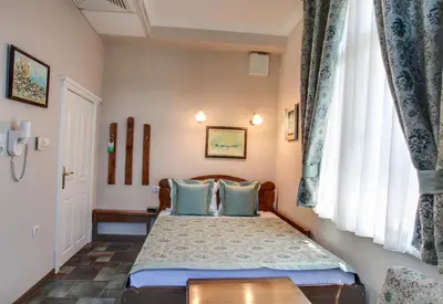 a bedroom with a bed with blue pillows at Hotel Odeon in Plovdiv