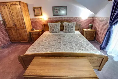 a bedroom with a large bed and wooden furniture at Hotel Odeon in Plovdiv