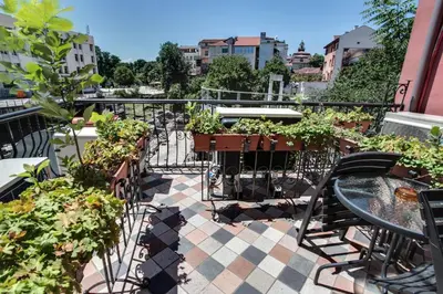 a balcony with a table and chairs and plants at Hotel Odeon in Plovdiv
