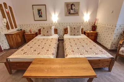a hotel room with two beds and a table at Hotel Odeon in Plovdiv