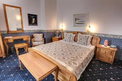 a bedroom with a bed and a table and chairs at Hotel Odeon in Plovdiv