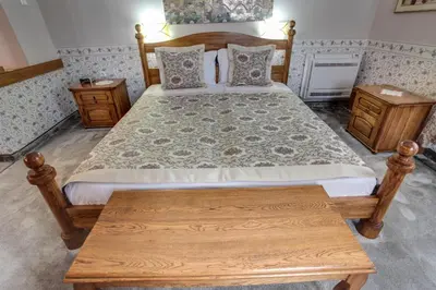 a bedroom with a wooden bed with a wooden table at Hotel Odeon in Plovdiv