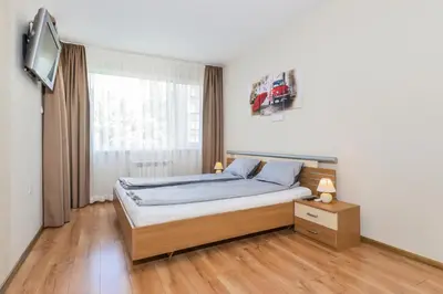 a bedroom with a bed and a tv on a wall at The M Place by Flat Mаnager in Sofia