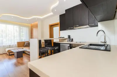 a kitchen with a counter top and a living room at The M Place by Flat Mаnager in Sofia