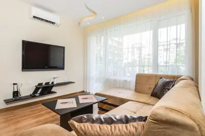 a living room with a couch and a flat screen tv at The M Place by Flat Mаnager in Sofia