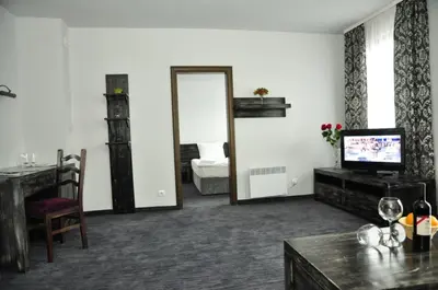 a living room with a television and a mirror at 3 Mountains Hotel in Bansko