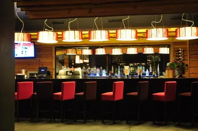 a bar with red bar stools in a restaurant at 3 Mountains Hotel in Bansko