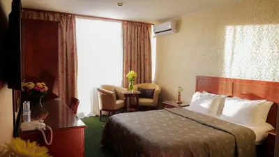 a hotel room with a bed and a chair and a window at Hotel Bankya Palace in Bankya