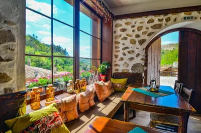 a living room with a table and a large window at Manoleva House in Melnik