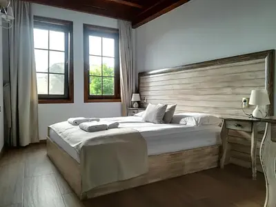 a bedroom with a large bed with a wooden headboard at Manoleva House in Melnik