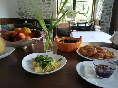 a wooden table with plates of food on it at Manoleva House in Melnik