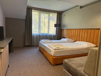 a hotel room with two beds and a television at Family Hotel Delta in Ognyanovo