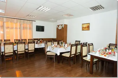 a dining room with white tables and chairs at Family hotel Iskar in Govedartsi