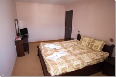 a bedroom with a bed with towels on it at Family hotel Iskar in Govedartsi